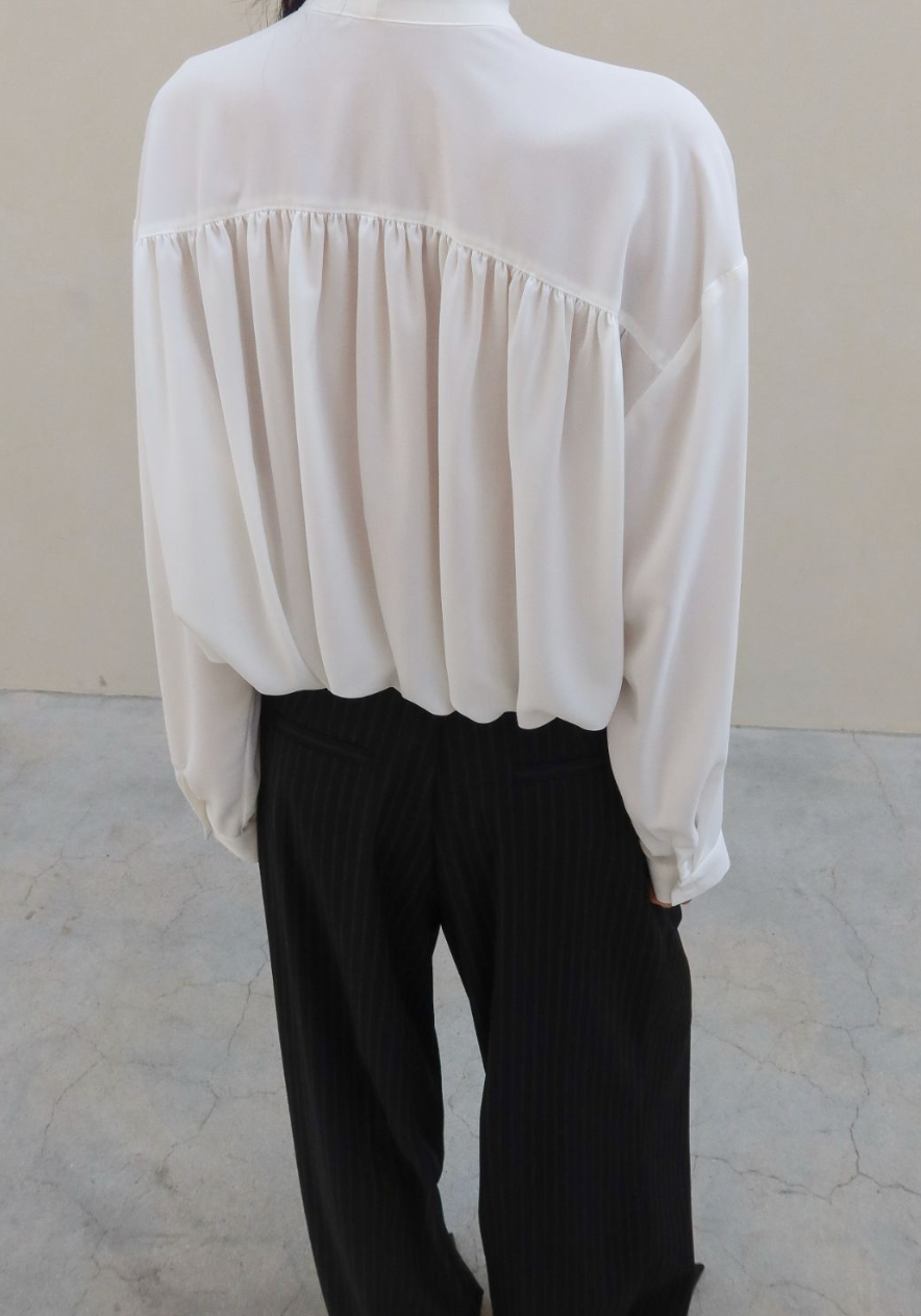 White blouse and black pants on a plain background
