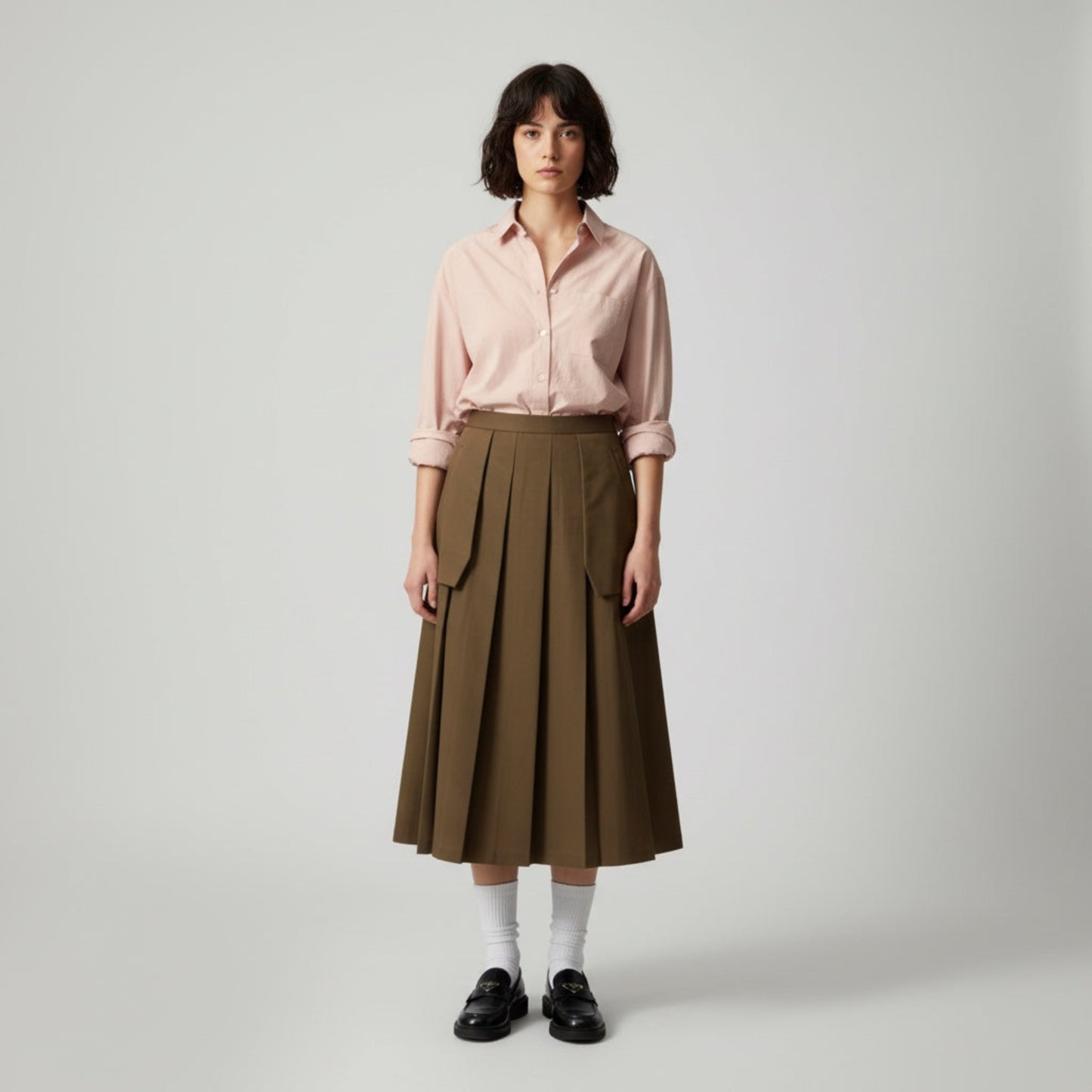 Woman wearing a pink shirt and brown skirt on a white background