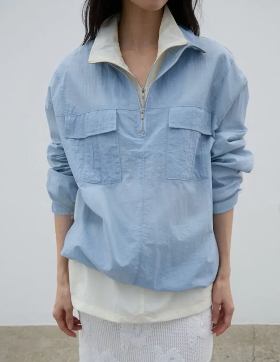 Person wearing a light blue corduroy shirt with a white collar against a plain background