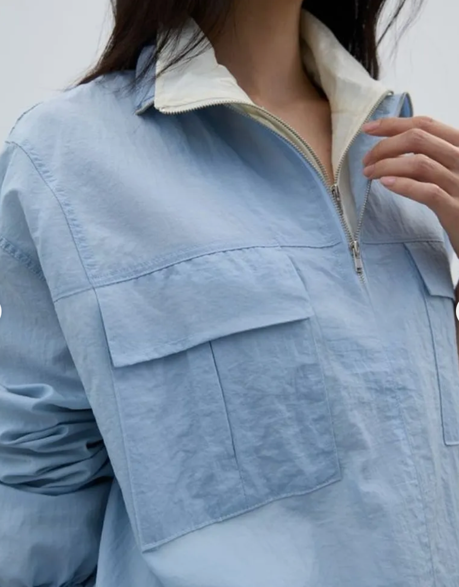 Light blue jacket with a zipper and pocket detail