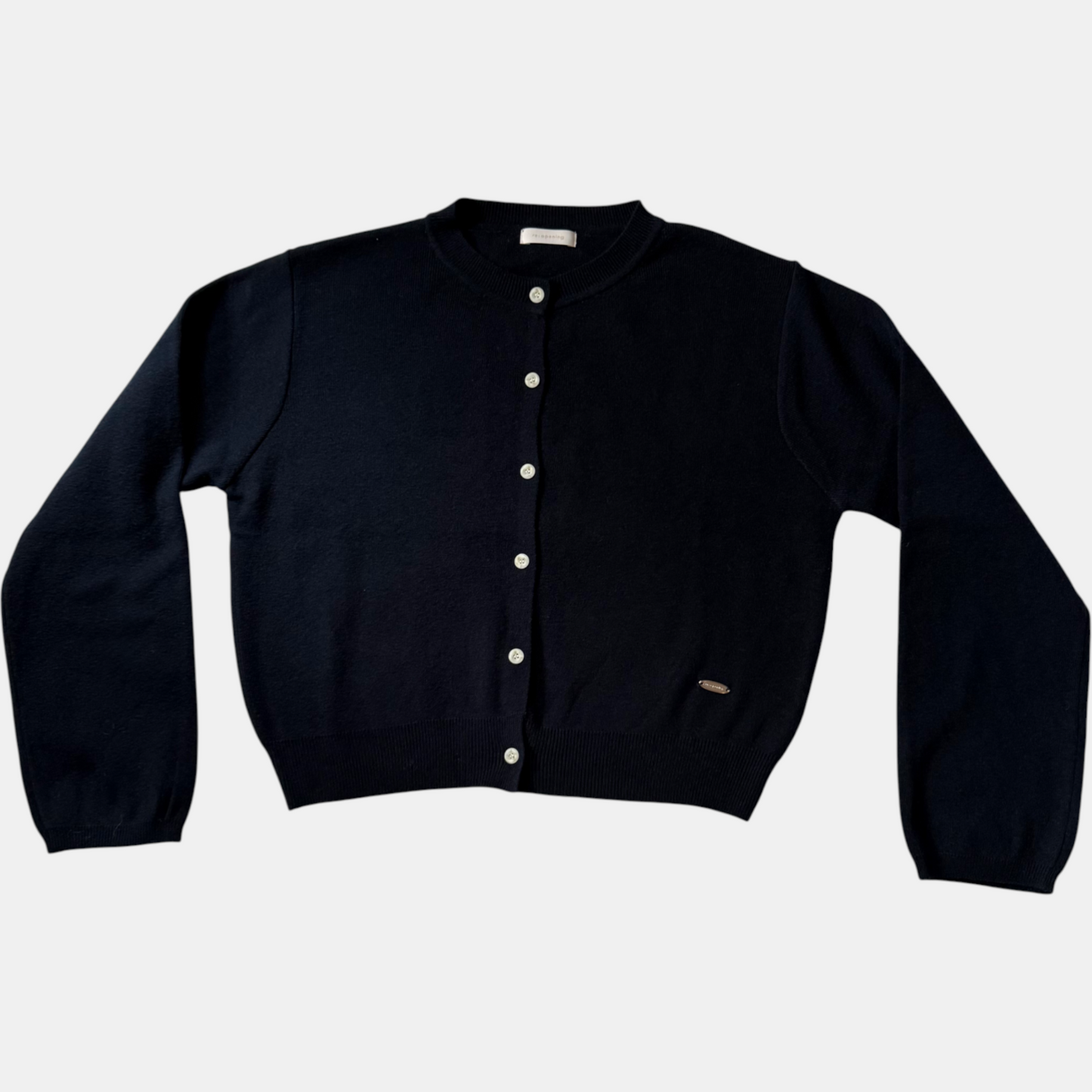 Blue cardigan with white buttons on a light gray background