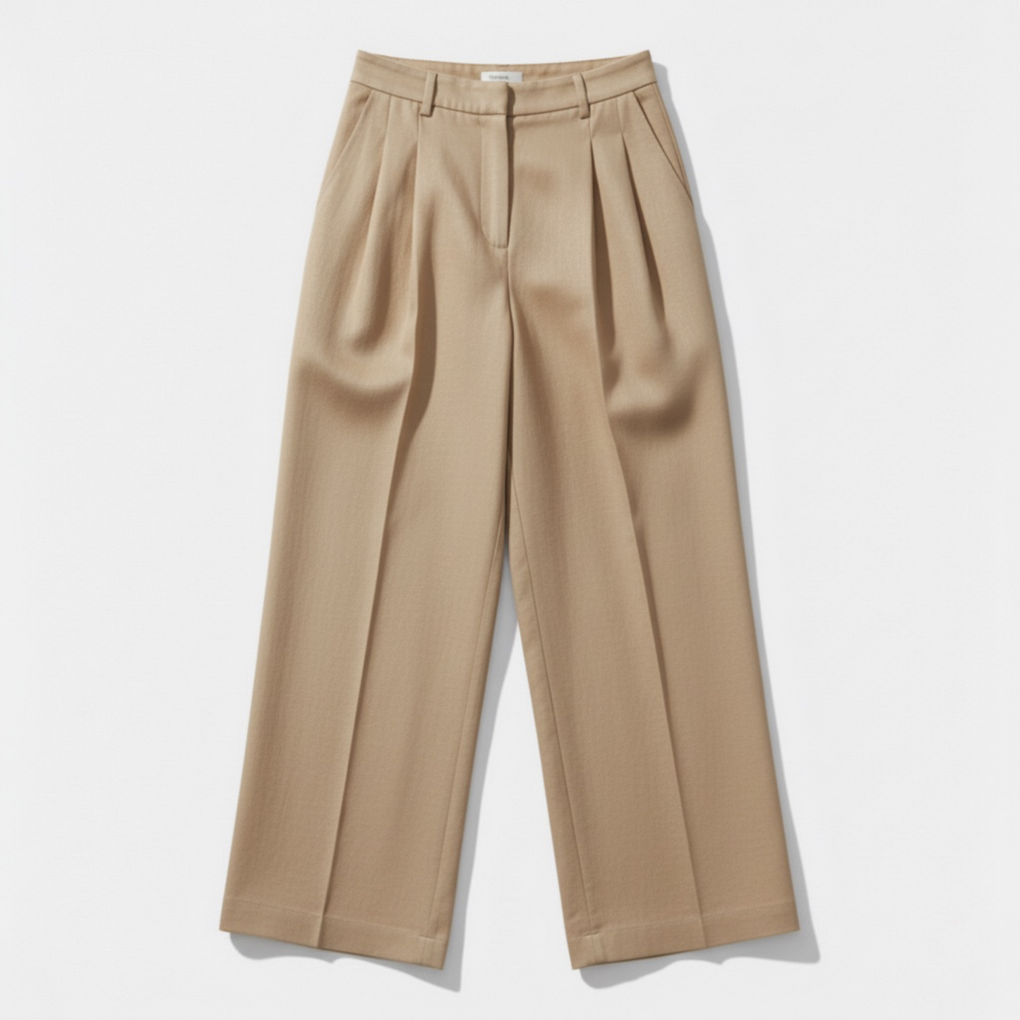Beige pleated pants on a light gray background