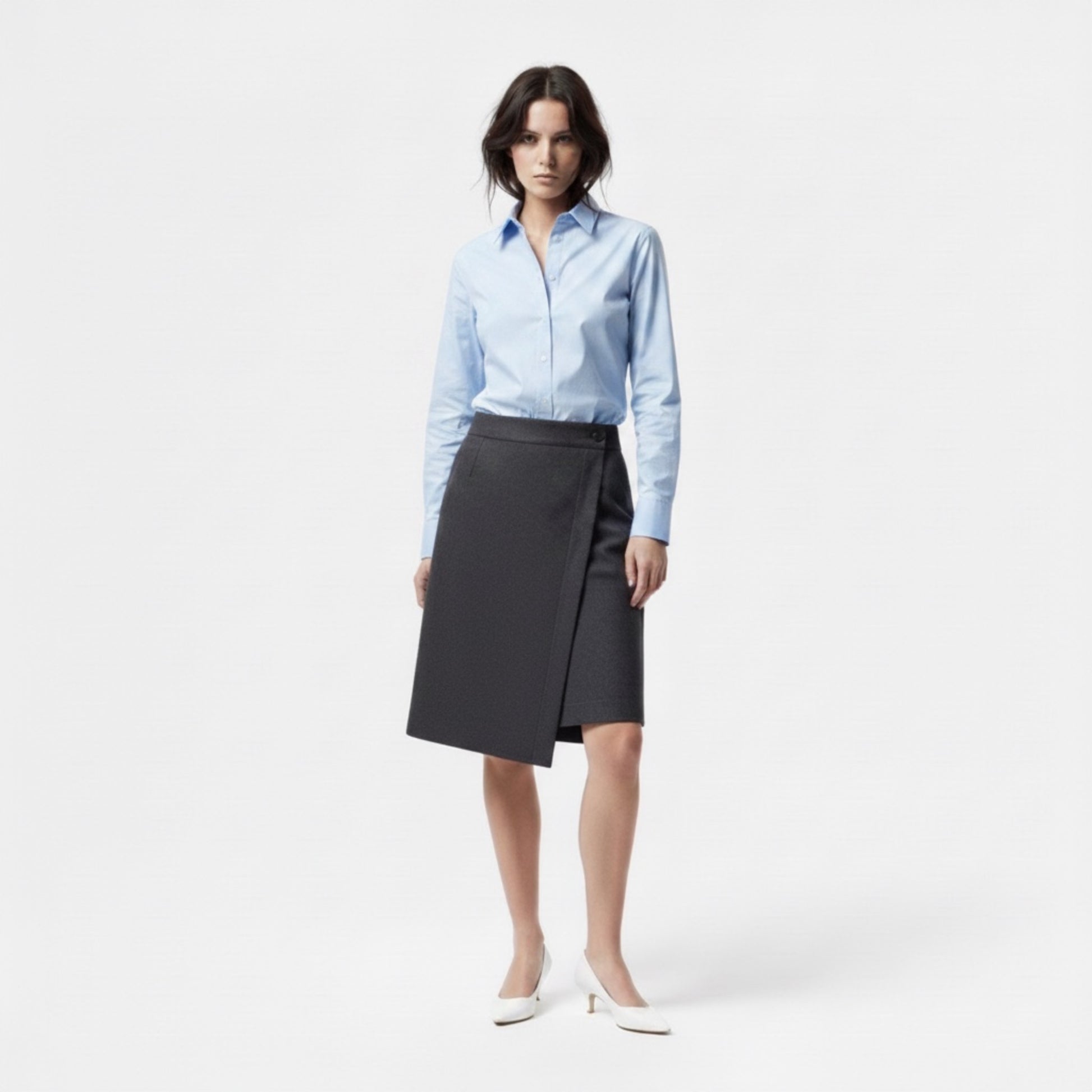 Woman wearing a light blue shirt and black skirt on a white background