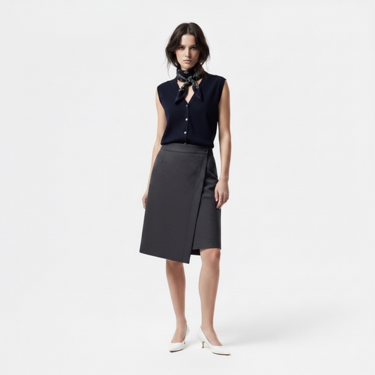 Woman wearing a navy sleeveless top and black skirt on a white background
