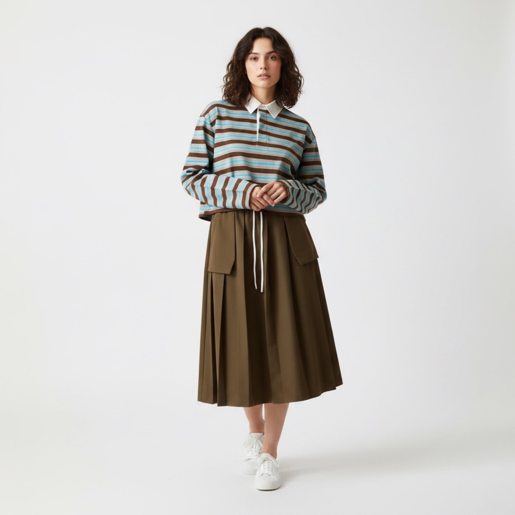 Woman wearing a striped sweater and brown skirt on a white background
