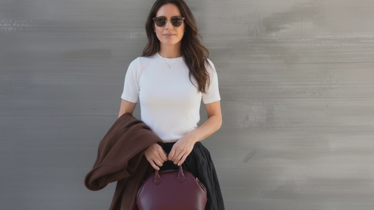 Load video: A brunette wearing grey cardigan and grey skirt.