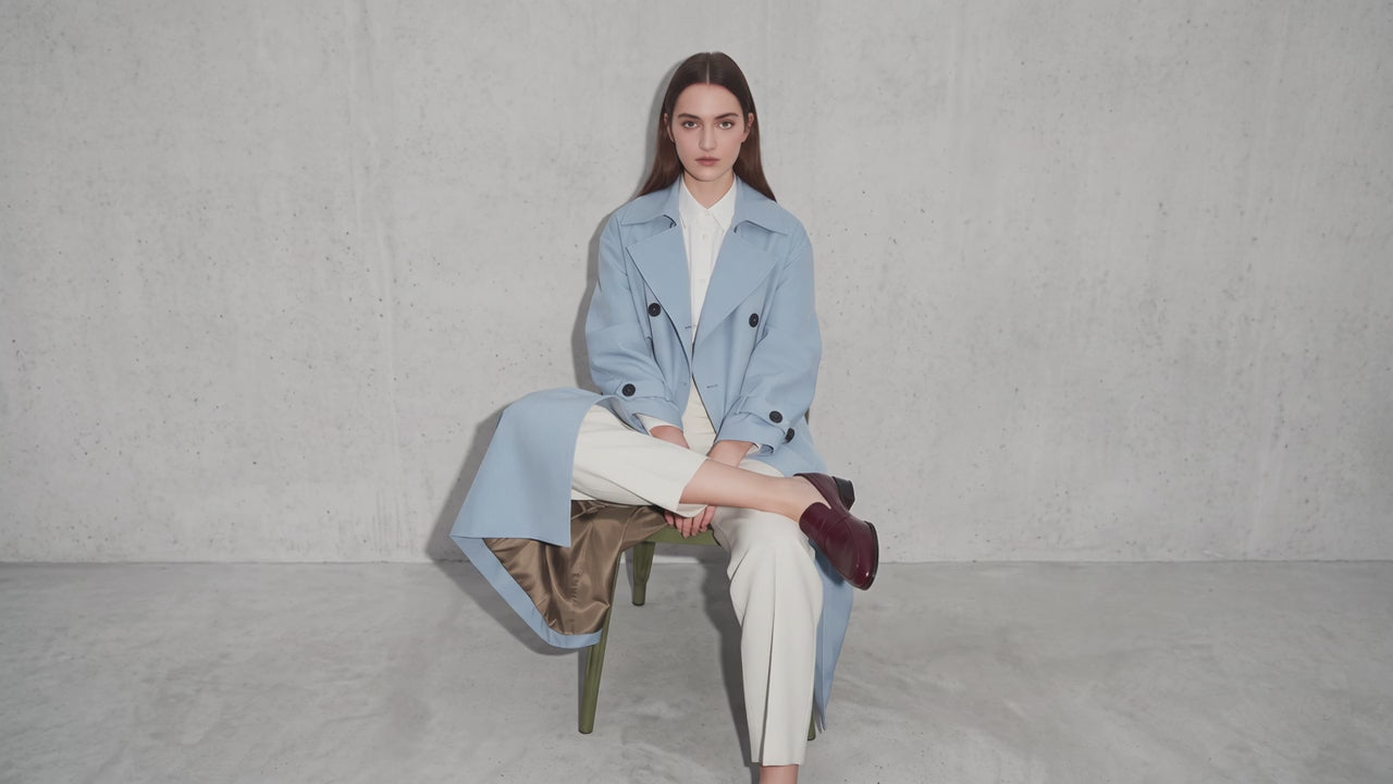 Load video: A brunette wearing grey cardigan and grey skirt.